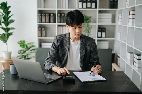 Woman freelancer is working her job on computer tablet and laptop Doing accounting analysis report real estate investment data, Financial at office. © Nuttapong punna