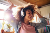 Happy funny gen z teen girl wearing headphones, dancing and listening music