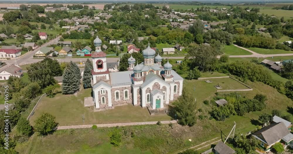 aerial view over othodox or catholic church in countryside on green hill
