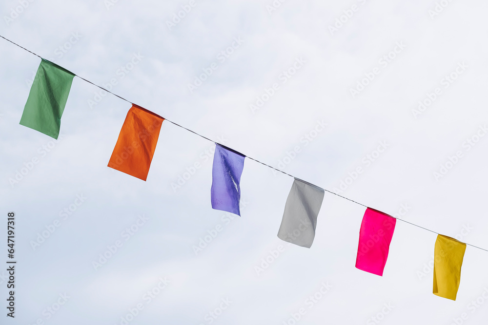 Guirlande décorative avec des fanions colorés suspendue dans une rue en ville