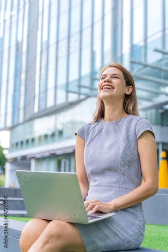 Young caucasian businesswoman working remotely outside her office building Free Download Young caucasian businesswoman working remotely outside her office building - GFXLoad