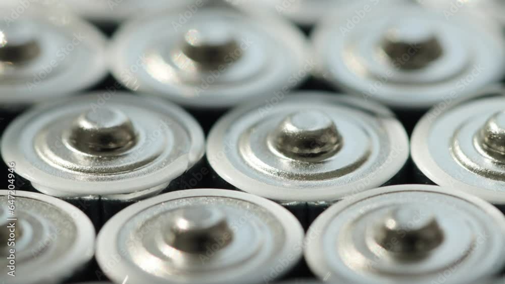 A lot of alkaline charged batteries with different polarity and power. Battery recycling, plus and minus, background. Rotation around its own axis. Macro A lot of alkaline charged batteries with different polarity and power. Battery recycling, plus and minus, background. Rotation around its own axis. Macro
