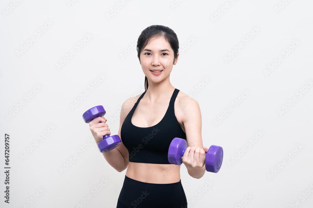 Asian woman wearing black workout clothes with smiling face Exercising with purple dumbbells with cheerfulness against a white background or isolated Asian woman wearing black workout clothes with smiling face Exercising with purple dumbbells with cheerfulness against a white background or isolated