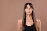 Hair styling. Beautiful woman with straight long hair on pale brown background, space for text