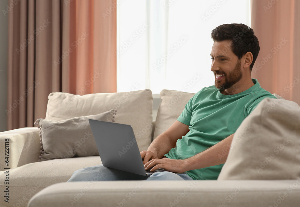 Man using laptop on sofa at home Man using laptop on sofa at home