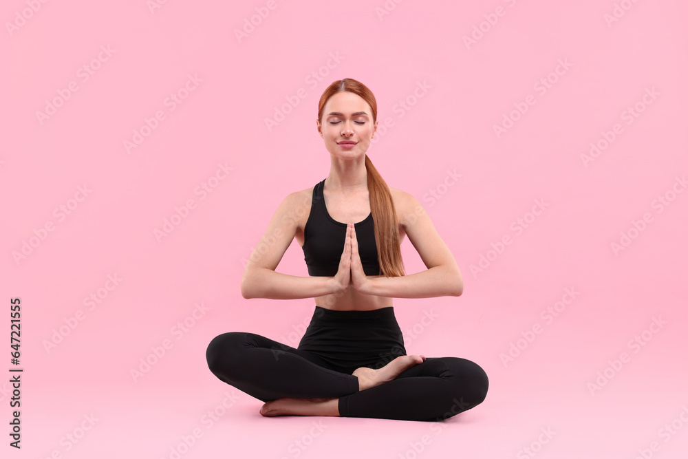 Beautiful young woman practicing yoga on pink background. Lotus pose Beautiful young woman practicing yoga on pink background. Lotus pose