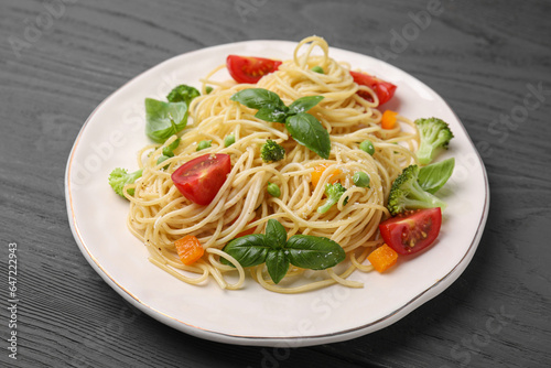 Delicious pasta primavera with tomatoes, basil and broccoli on grey table, closeup