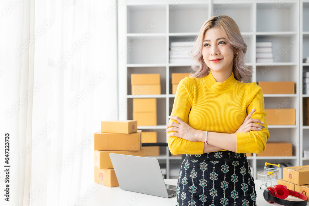 Beautiful young Asian woman working with online sales box with laptop taking online orders at home, SME business concept Beautiful young Asian woman working with online sales box with laptop taking online orders at home, SME business concept