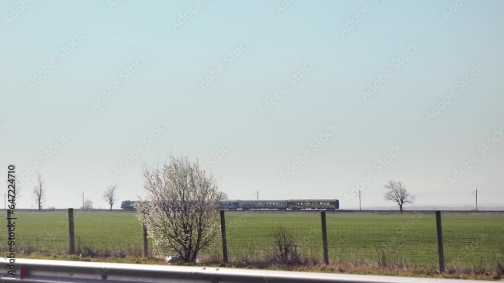 Old train moving on railway in agriculture field spring landscape, slow motion