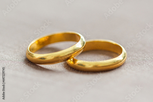 Two wedding gold rings on brown background