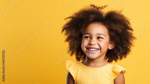 Smiling african american girl on a yellow background © Katya