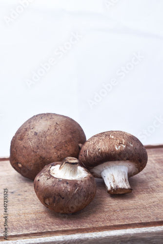 large edible mushrooms on a wooden board with a white background