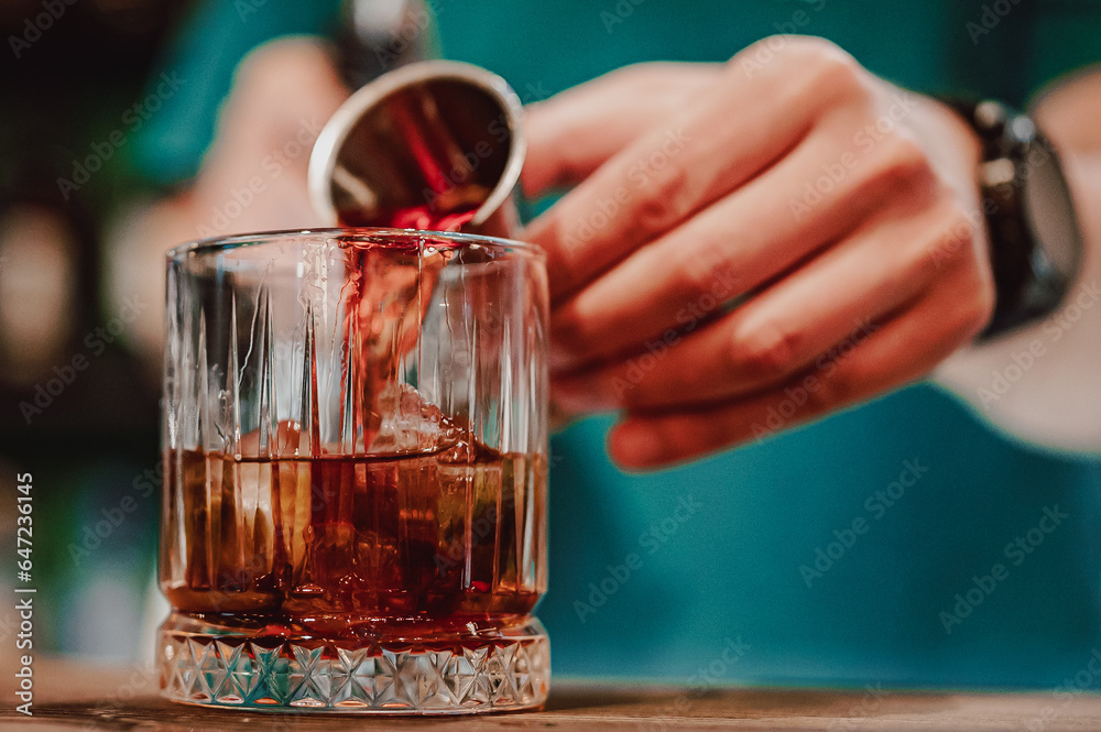 bartender hand making negroni cocktail in bar bartender hand making negroni cocktail in bar