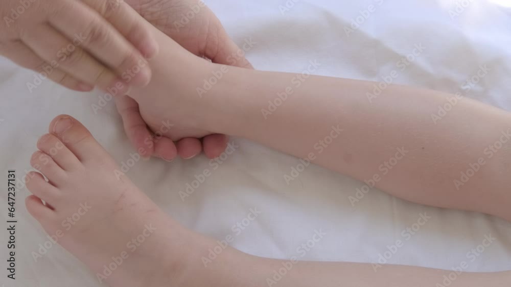 close-up toddlers bare feet, female hands gently knead the child's legs, make therapeutic, preventive massage, strengthen musculoskeletal system, stimulate physical development, prevention of flat close-up toddlers bare feet, female hands gently knead the child's legs, make therapeutic, preventive massage, strengthen musculoskeletal system, stimulate physical development, prevention of flat