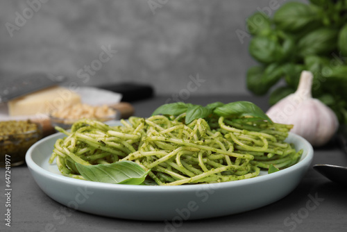 Delicious pasta with pesto sauce and basil on grey wooden table  closeup