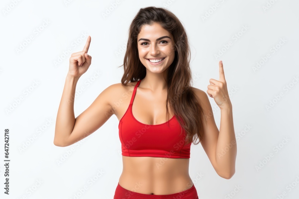 Portrait of a smiling sportswoman in red sportswear showing her biceps isolated on a white background and Looking at the camera. Portrait of a smiling sportswoman in red sportswear showing her biceps isolated on a white background and Looking at the camera.