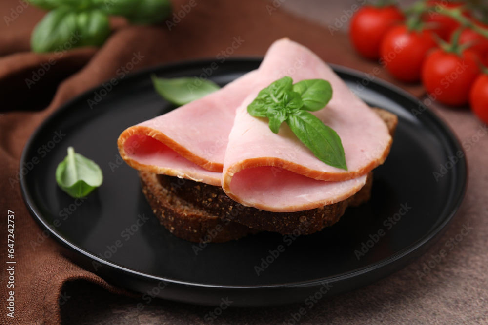 Delicious sandwich with ham on brown table, closeup Delicious sandwich with ham on brown table, closeup