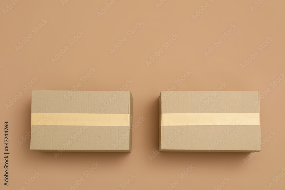 Cardboard boxes on light brown background, flat lay. Space for text Cardboard boxes on light brown background, flat lay. Space for text