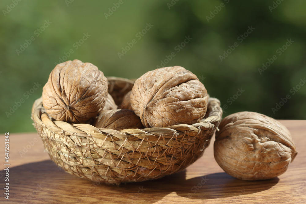 walnut in a wicker basket on wooden surface. walnut in a wicker basket on wooden surface.