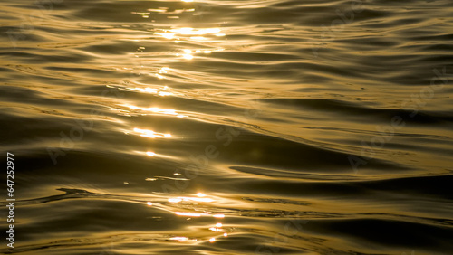 abstract waves forming on the sea at sunset ,yellow black sunset background