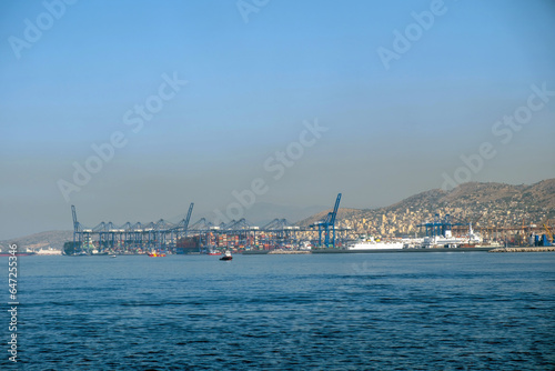 Piraeus port, Attica Greece. Industrial zone, container terminal, moored cargo ship. Sea, blue sky.