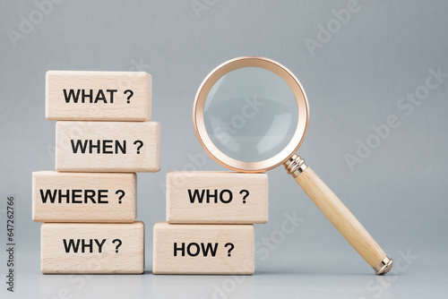 Qurstion words on stack of wood blocks with magnifying glass, questions analysis, investigation, test, quiz, or marketing, and FAQs concept