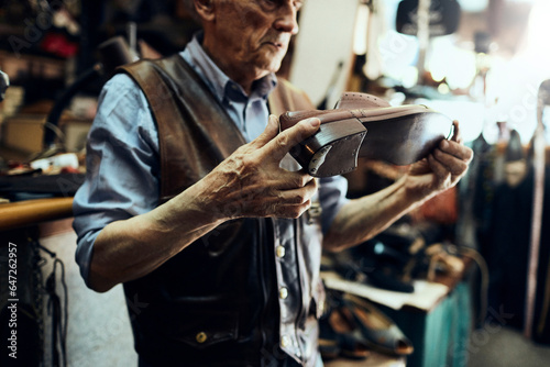 Εκτύπωση καμβά Senior male cobbler restoring a shoe in his old workshop in the city