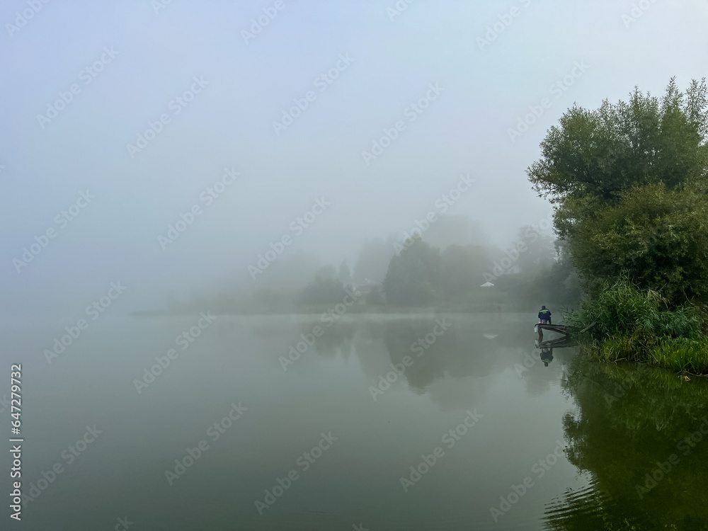 Mystical morning at the fog-kissed lake, where nature's beauty emerges through the ethereal mist. Mystical morning at the fog-kissed lake, where nature's beauty emerges through the ethereal mist.