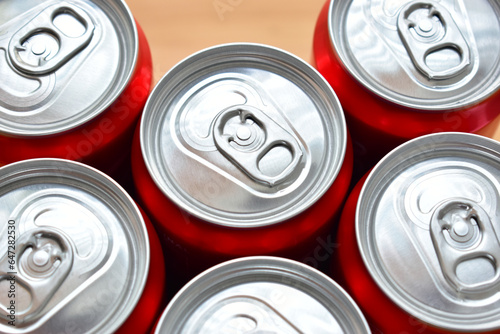 close up group of aluminium red cans soft drink put on brown wooden table