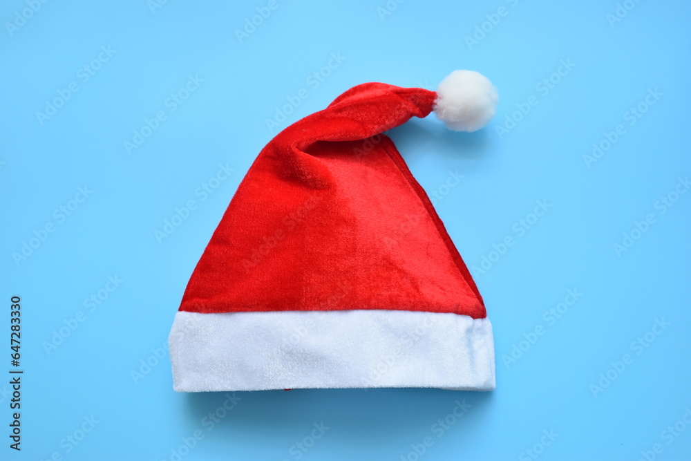 Santa claus red wool winter hat on blue background, christmas decoration Santa claus red wool winter hat on blue background, christmas decoration