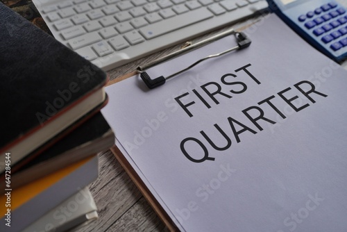 Close up image of paper clipboard with text FIRST QUARTER on office desk photo