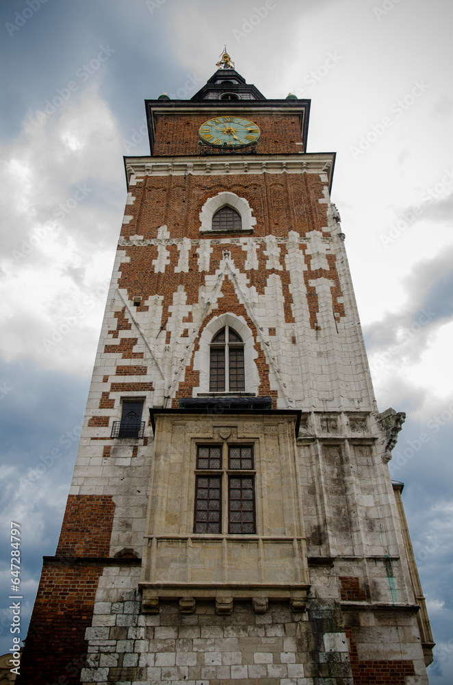 Premises of the town hall with clock in the old town in the center of Krakow against the background of a cloudy sky
