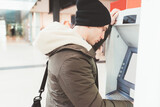 caucasian man using cash dispenser