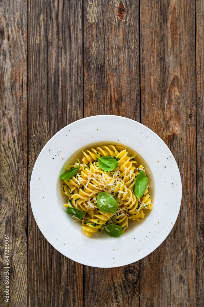 Pasta with basil - noodles witch parmesan cheese, oil olive  and basil leaves on wooden background
