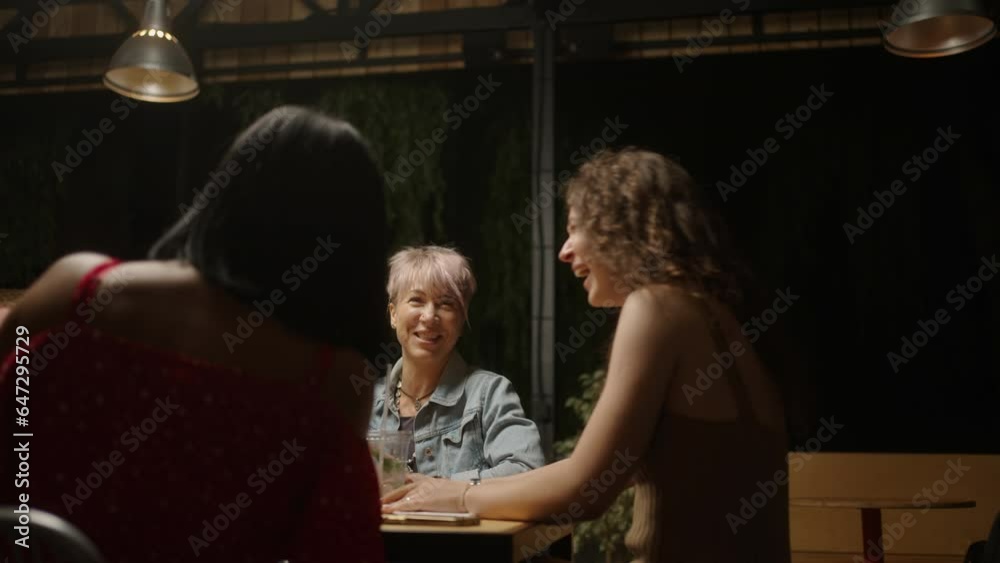 Family Dinner In Backyard In Summer Evening, Diverse Women Chatting And Laughing, Sitting At Table