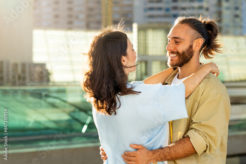 Konstfotografi Cheerful young caucasian guy in casual meets woman, hugs at train station or air