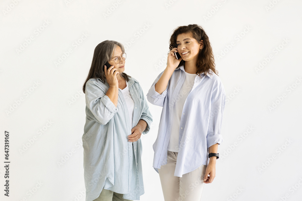 Smiling caucasian old and adult women in casual calling by phone, enjoy free time Smiling caucasian old and adult women in casual calling by phone, enjoy free time