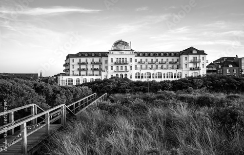 Historic health resort with seaview on Juist island. Monument and toursit attraction in the dunes near main beach. Wooden footbrige with love locks on a sunny summer evening. Black and white vintage. photo