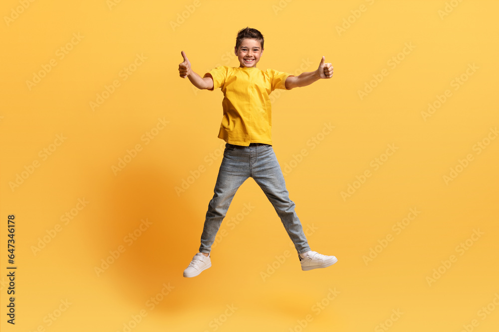 Cute preteen cheerful boy jumping in the air