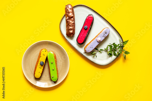 Set of various glased eclairs with chocolate and berrie, top view photo