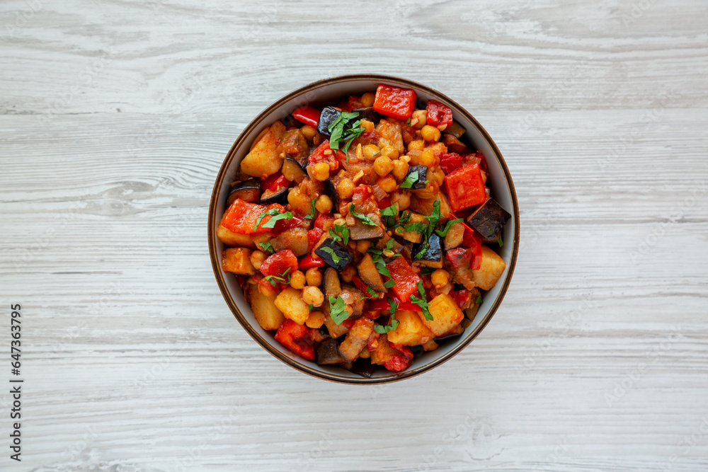 Homemade Eggplant Potato Tomato Stew with Parsley in a Bowl, top view. Flat lay, overhead, from above. Homemade Eggplant Potato Tomato Stew with Parsley in a Bowl, top view. Flat lay, overhead, from above.