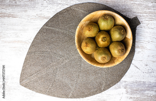 Above biew on ripe green kiwi fruits inside a wooden bowl. Healthy fruits concept. photo