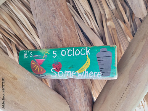 Summer seaside view poster. Vector background. Tropical beach bar sign, Tropical Beach Bar Wood Board Signpost, with cocktail and palm tree leaves. 5 o clock somewhere