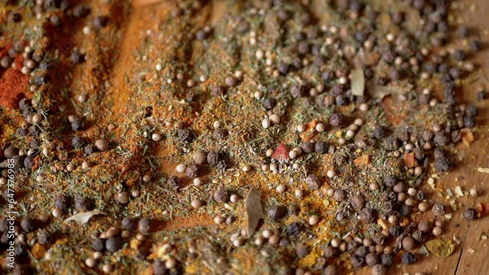 Stirring Indian Spices with a Wooden Spatula on Colorful Spinning Background. Close up. Allspice peppercorns, dried herbs, dill, paprika, turmeric, oregano. Texture, pattern. Palette dried seasoning. Stirring Indian Spices with a Wooden Spatula on Colorful Spinning Background. Close up. Allspice peppercorns, dried herbs, dill, paprika, turmeric, oregano. Texture, pattern. Palette dried seasoning.