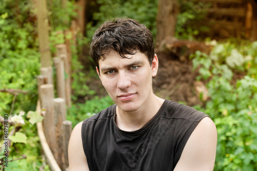 A happy guy is no longer a teenager with a thoughtful philosophical look, after a walk in forest, he calms down, thinks and decides how to live on. Nice guy 19 years old in nature