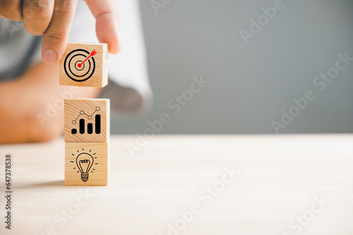 A businessman's hand skillfully stacks wood blocks, depicting a strategic business plan and Action plan. This concept represents business development and growth in the professional realm. photo