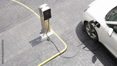 Progressive innovation urban electric on-street charging station with electric vehicle battery being charged with green energy for environmental concern in order to reduce CO2 emission.