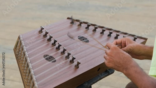 Close-up of street musician playing on santoor or cimbalom, slow motion. Music and arts concept photo
