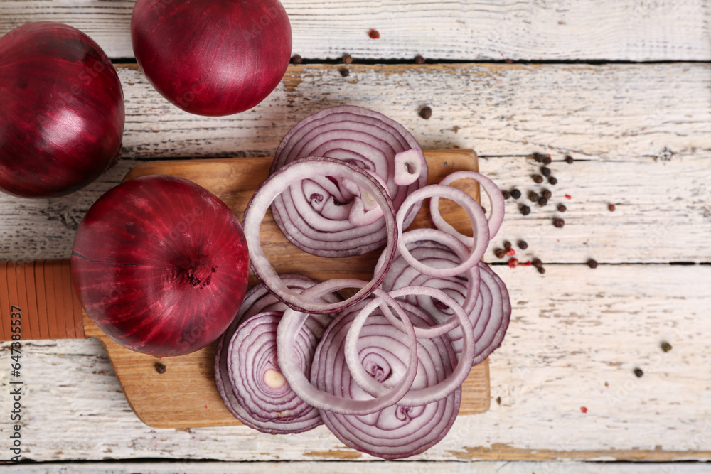 Board with slices of fresh red onion and peppercorn on white wooden background Board with slices of fresh red onion and peppercorn on white wooden background