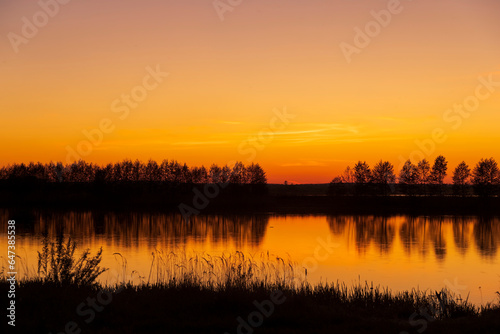 beautiful orange-yellow sunset on the lake in spring